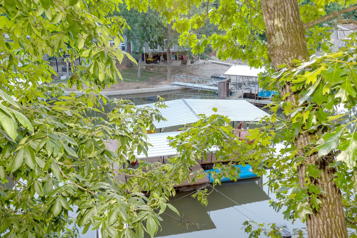 This image shows a floating dock surrounded by lush trees and calm water. The dock invites swimming, lounging, or launching paddleboards, echoing the activities described in the section. The tranquil natural setting is ideal for families to gather, swim, or relax safely.